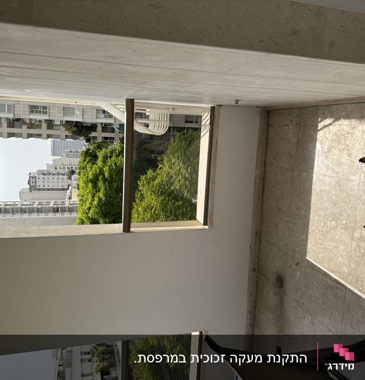 מרפסת עם מעקה זכוכית ונוף עירוני